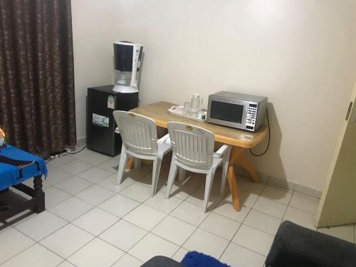 a kitchen with a table with two chairs and a microwave at Sweet Awesome One bedroom stay. in Eldoret