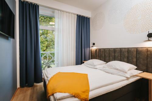 a bedroom with a bed and a window at Hestia Hotel Haapsalu SPA in Haapsalu