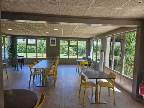 ドーヴィルにあるカンパニール ドーヴィル サン タルヌーのテーブルと椅子と窓のあるダイニングルーム