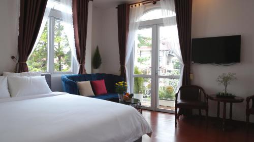 大叻的住宿－FLORA HOME DALAT，一间卧室设有一张床和一个大窗户