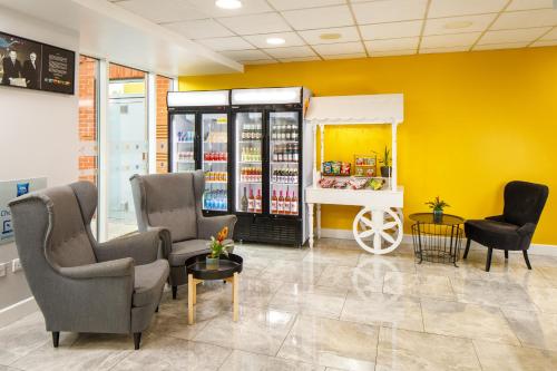 a waiting room with two chairs and a shelf of products at ibis budget Sheffield Arena in Sheffield