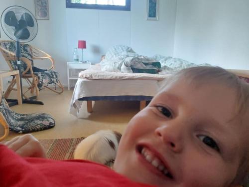 a young child laying on the floor in a bedroom at Backyard Cabin With Veranda By Kemi River In Keminmaa in Kemi