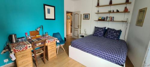 a bedroom with a bed and a desk in it at Bienvenue chez Lilaroma in Mérignac