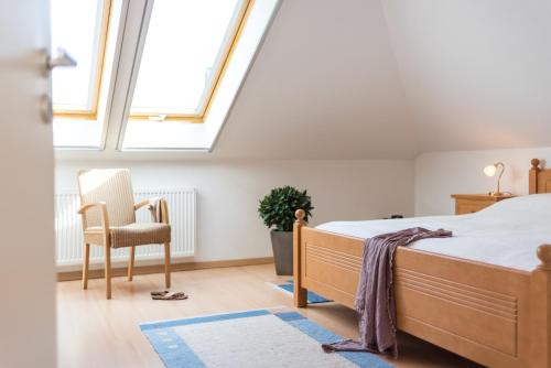 a bedroom with a bed and a chair and a window at Likedeeler Weg 1 Whg 24 in Zingst