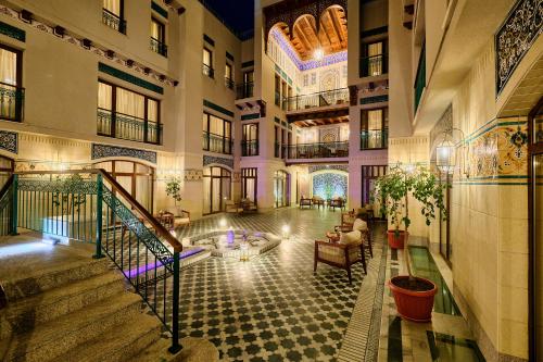 a lobby of a building with a fountain in the middle at Kosh Havuz boutique hotel in Samarkand