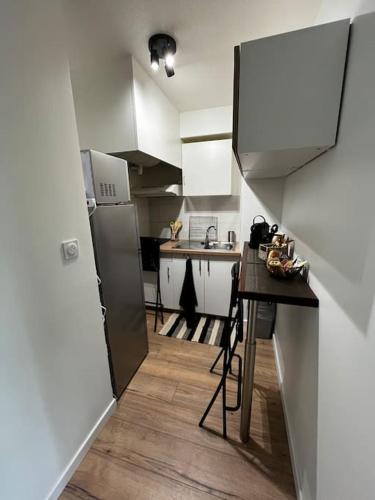 une petite cuisine avec une table et un réfrigérateur dans l'établissement Charmant T2 dans Toulouse, à Toulouse
