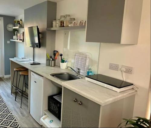 a kitchen with a sink and a counter top at Elkstone Studio Private Hottub Pet Friendly in Malvern Link