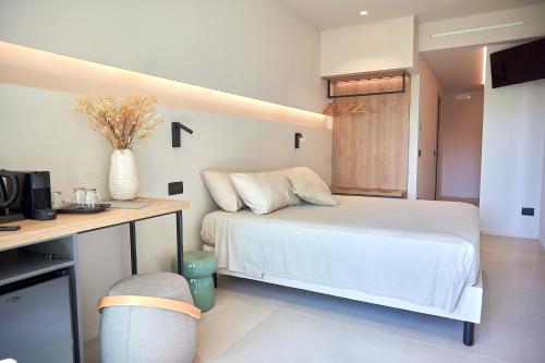a bedroom with a bed and a desk with a television at White Coast in Polignano a Mare