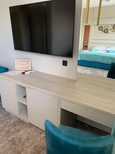 a desk with a television and a blue chair at Hotel Coroana in Tîrgu Frumos