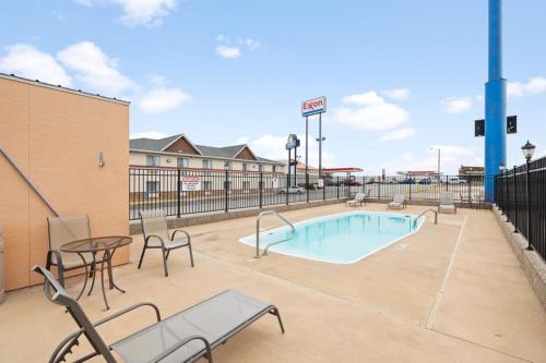 a swimming pool with a table and chairs and a building at Travelodge by Wyndham Wall in Wall