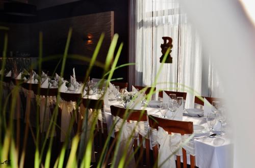 a dining room with white tables and chairs with glasses at Hotel Stara Kamienica in Piekary Śląskie