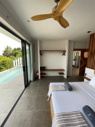 LOLISEA Luxe view villas في سالاد بيتش: غرفة نوم مع مروحة سقف ومسبح
