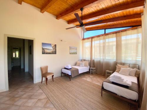 ein Wohnzimmer mit 2 Betten und einem großen Fenster in der Unterkunft Nido al Lido in Noto