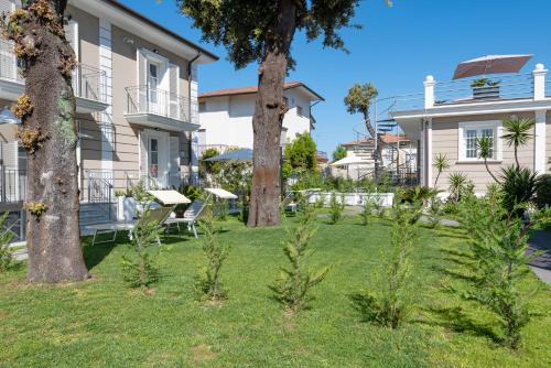 ein Haus mit zwei Bäumen im Hof in der Unterkunft Lido Luxury Villas in Lido di Camaiore