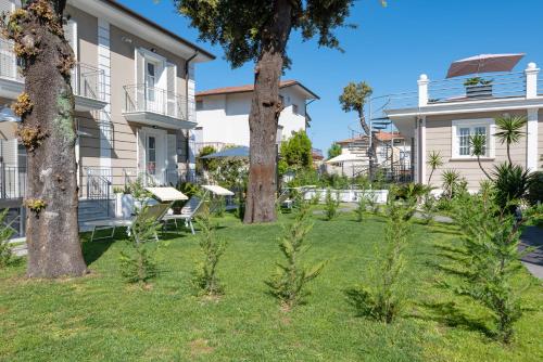a house with two trees in the yard at Lido Luxury Villas in Lido di Camaiore