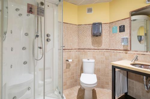 uma casa de banho com um chuveiro, um WC e um lavatório. em Hotel Alda Borox em Borox