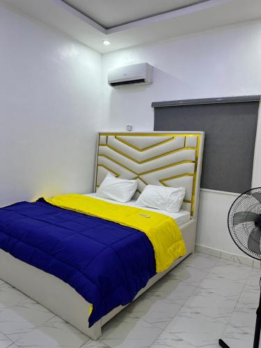a bedroom with a bed with a yellow and blue blanket at Magnanimous Apartments 1bedroom flat at Ogudu in Lagos