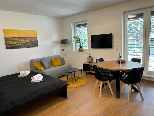 a room with a bed and a table and a couch at Apartmány Kyjov in Kyjov