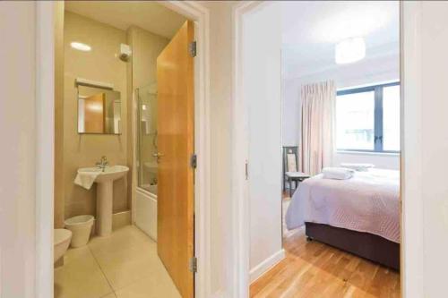 a bedroom with a bed and a bathroom with a sink at Luxury Two Bedroom Apt in Dublin in Dublin