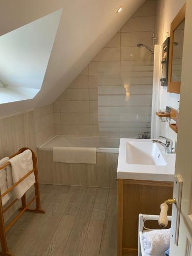 un bagno con lavandino e vasca da bagno di LE CLOS DU GOLF a Dame-Marie-les-Bois