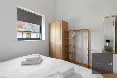 Habitación blanca con cama y ventana en Smythen St, 2 bed apartment with balcony, en Exeter