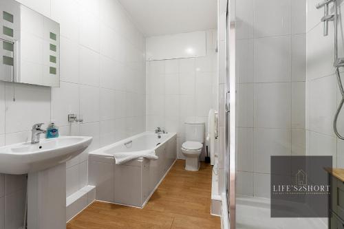 Baño blanco con lavabo y aseo en Smythen St, 2 bed apartment with balcony, en Exeter