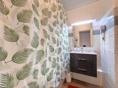 uma casa de banho com uma cortina de chuveiro e um lavatório em Ty Kinoleta Anse des rochers em Saint-François