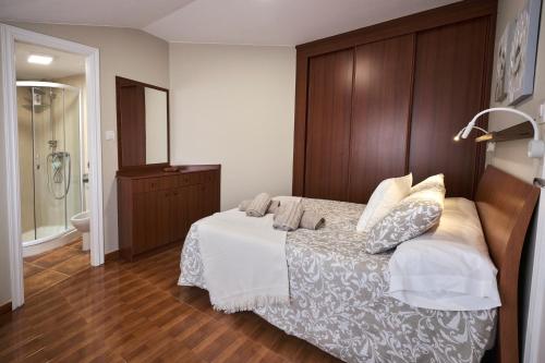 1 dormitorio con 1 cama grande y cabecero de madera en dunas da barra, en Ponteceso