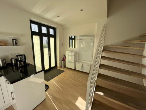 a living room with a staircase in a house at Ferienwohnung "Julie" - Haus Alando in Prora