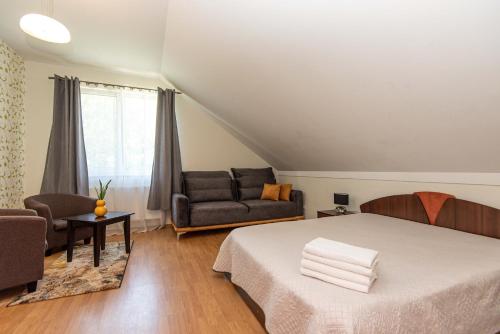 a bedroom with a bed and a couch at Guest House Pasaulio Krastas in Palanga