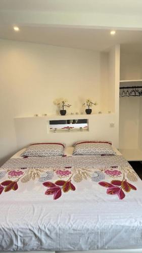 - une chambre avec un grand lit fleuri dans l'établissement La Suite Sun Set, à Tremblay-en-France