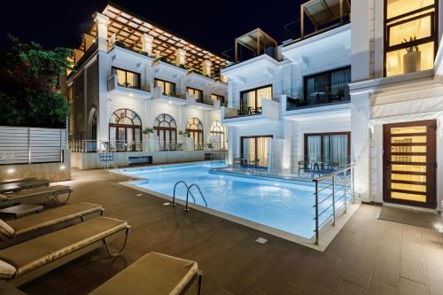 a large swimming pool in front of a building at Diverso Platamon, Luxury Hotel & Spa in Platamonas