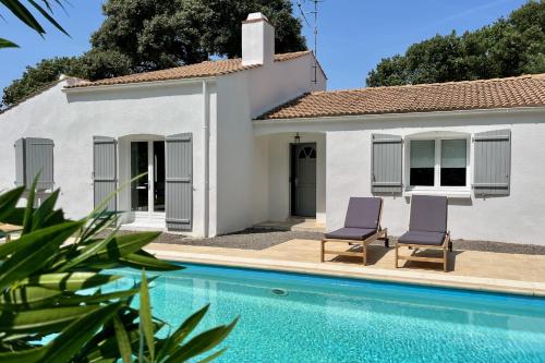 une villa avec piscine devant une maison dans l'établissement Villa des Pins - Piscine & proche de la plage, à Saint-Hilaire-de-Talmont