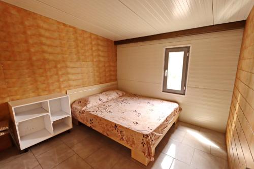 een kleine slaapkamer met een bed en een raam bij Valea Fazanilor in Durleşti