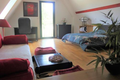 - une chambre avec un lit et une table basse dans l'établissement Le TIVOLI, à Montignac