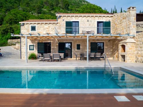 eine Villa mit einem Pool und einem Haus in der Unterkunft Villa Marlea Konavle Dubrovnik in Gruda