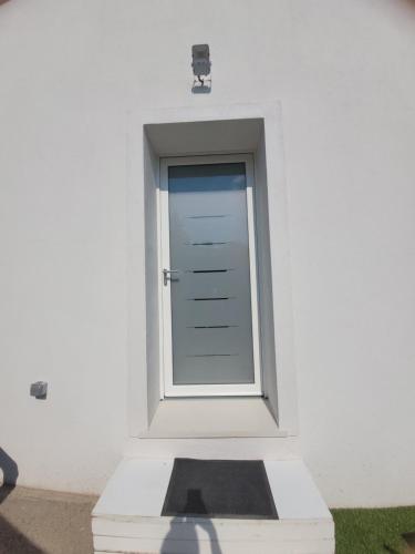 a door in a white wall with a window at Villa Les palmiers en Provence in Besse-sur-Issole