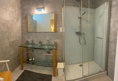 y baño con lavabo de cristal y ducha. en Gîte UTAH - 4 personnes - Plages du débarquement, en Formigny