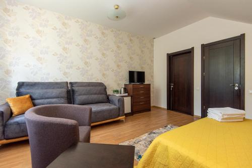 a living room with a couch and a bed and a tv at Guest House Pasaulio Krastas in Palanga