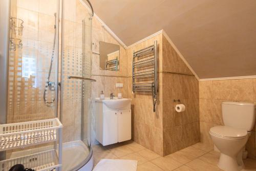 a bathroom with a shower and a toilet and a sink at Guest House Pasaulio Krastas in Palanga