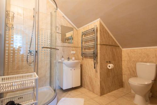 a bathroom with a shower and a toilet and a sink at Guest House Pasaulio Kraštas in Palanga