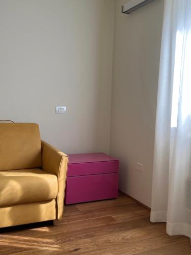 sala de estar con sofá y reposapiés rosa en Urbino Apartment - Urban Retreat, en Urbino