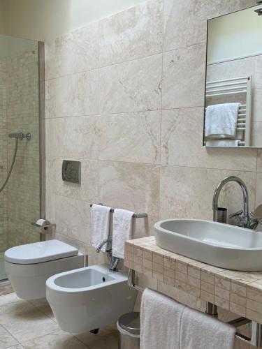 y baño con bañera, lavabo y aseo. en Urbino Apartment - Urban Retreat, en Urbino