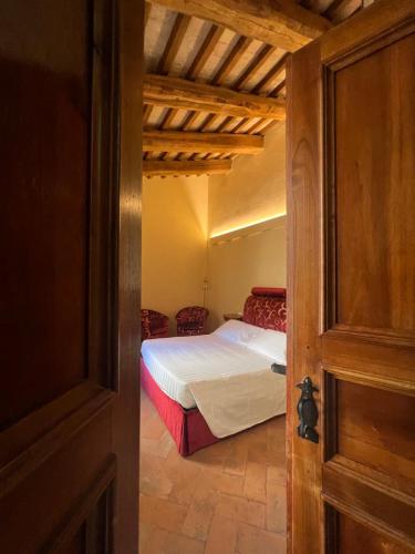 - Vistas a un dormitorio con cama y puerta en Urbino Apartments - Palazzo Paltroni Studio en Urbino
