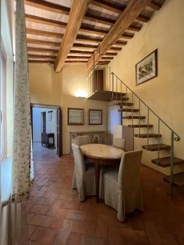 comedor con mesa y escalera en Urbino Apartments - Palazzo Paltroni Studio en Urbino