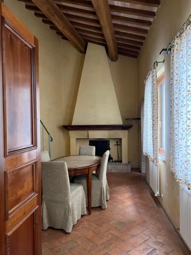une salle à manger avec une table, des chaises et une cheminée dans l'établissement Urbino Apartments - Palazzo Paltroni Studio, à Urbino