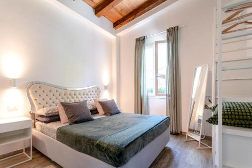 a white bedroom with a bed and a window at La Casetta in Riccò del Golfo di Spezia