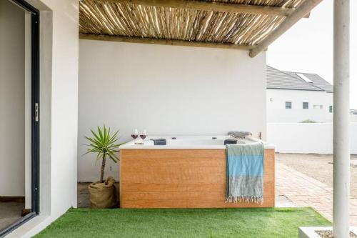 an outdoor bathtub in a patio with green grass at Granite View in St Helena Bay