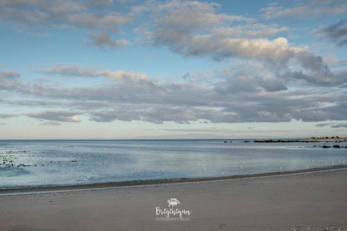 a beach with a cloudy sky and the ocean at Granite View in St Helena Bay
