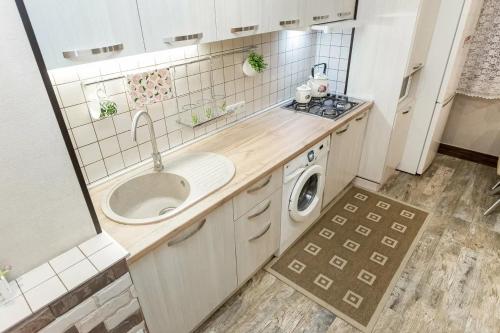 a kitchen with a sink and a washing machine at Арбат in Almaty